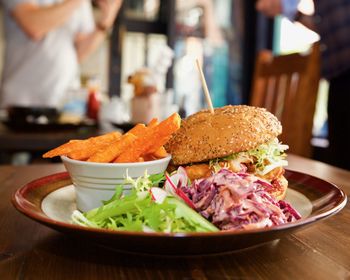 Close-up of burger with fries and salad on table