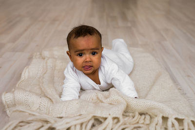 Portrait of cute boy lying on floor