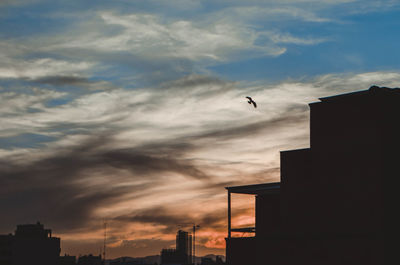 Low angle view of silhouette buildings against sky