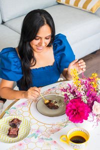 High angle view of young woman sitting on table