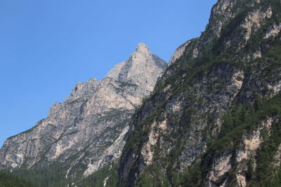 Low angle view of rocky mountains against clear sky