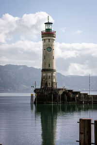 Lighthouse by sea against sky