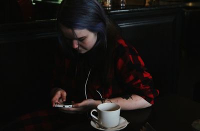 High angle view of woman using mobile phone at cafe