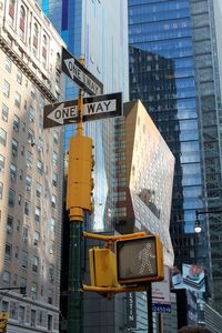 Road sign and traffic lights against buildings in new york. 