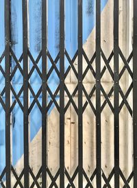 Metal fence by sea against building