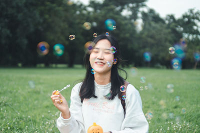 Young woman blowing bubbles