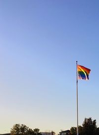 Low angle view of flag against clear blue sky