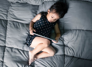 High angle view of baby lying on bed