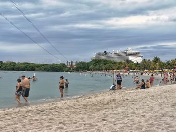 People at beach against sky