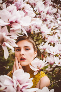 Portrait of young woman amidst pink flowers