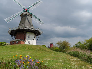 Traditional windmill on field against sky