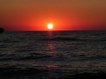 Scenic view of sea against orange sky