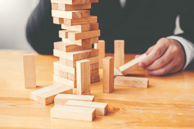 Close-up of hand holding stack of wooden table
