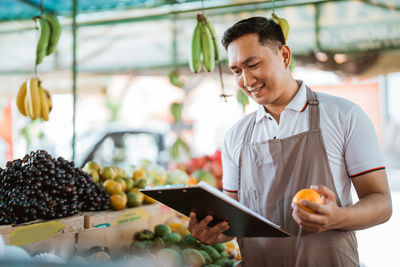 Midsection of man preparing food in greenhouse