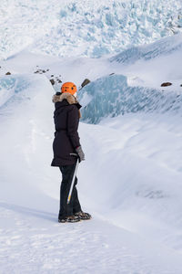 Man with umbrella on snowcapped mountain