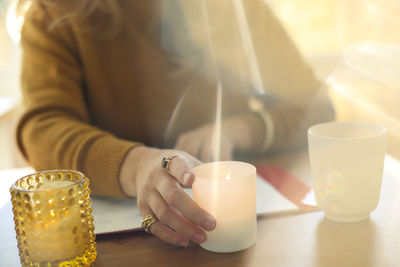 Midsection of woman using mobile phone on table