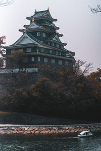 View of building by lake against sky