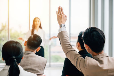 Rear view of woman with arms raised at home