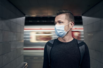 Portrait of young man standing in corridor