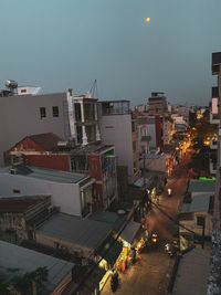 High angle view of illuminated street amidst buildings in city at dusk