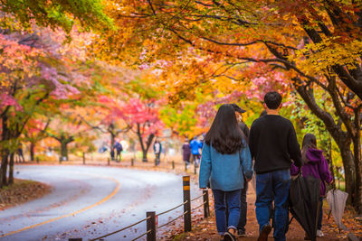 Rear view of people walking on road