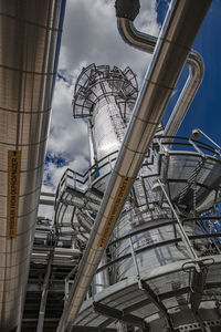 Low angle view of industry against sky in city