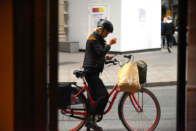Man with bicycle on street by building