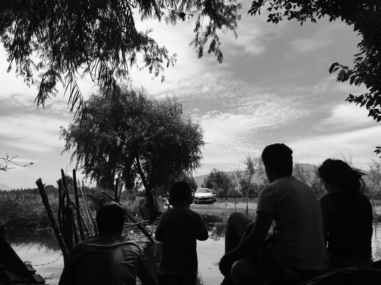 men, tree, lifestyles, leisure activity, sky, cloud - sky, togetherness, person, silhouette, rear view, bonding, nature, standing, friendship, cloudy, cloud, low angle view