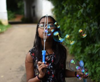Portrait of woman with bubbles in park