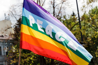 Low angle view of peace text on rainbow flag