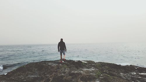 Rear view of man on beach against sky