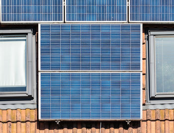 The red tilled roof covered with solar collar pannel, detail on pannels round roof windows