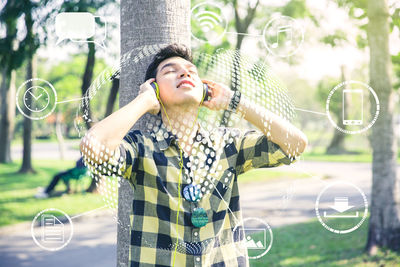 Digital composite image of man listening music with various icons