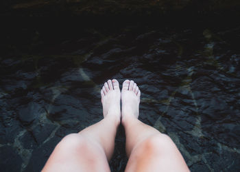 Female legs and feet getting wet in the river against river water