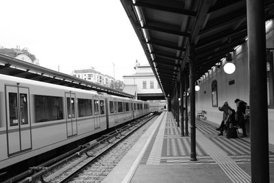 People waiting train at railroad station platform