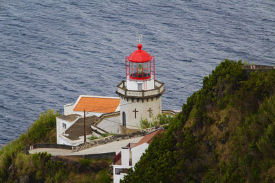 High angle view of red lighthouse by sea