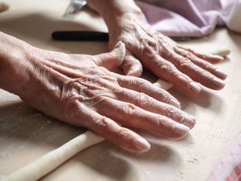 Close-up of hands preparing food on table