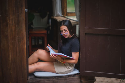 Young woman sitting on book