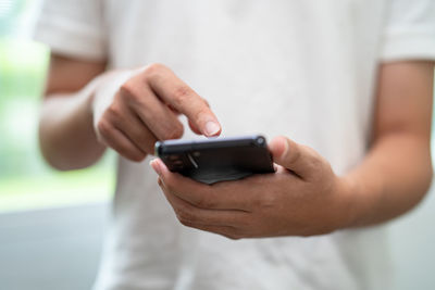 Midsection of man using mobile phone