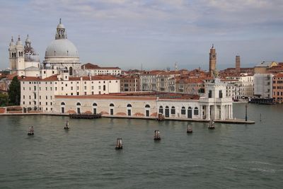 Boats in canal by buildings in city