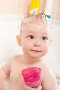 Girl playing with toys in bathtub
