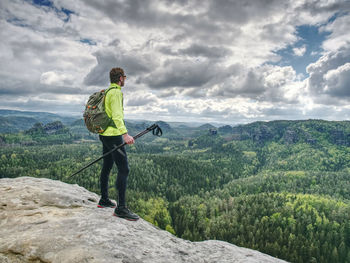 Spring rocky mountains. hiker with backpack stand on rocky view point. concept of active lifestyle