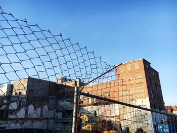 Low angle view of chainlink fence against sky