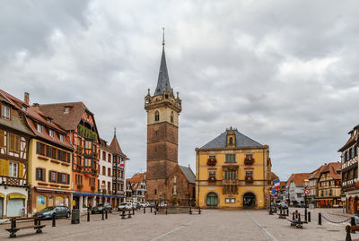 Buildings in city against cloudy sky