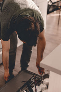 Rear view of man standing on table at home