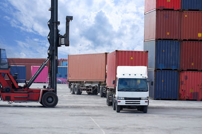 Stack of truck on pier against sky