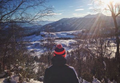 Rear view of man standing on snow covered landscape