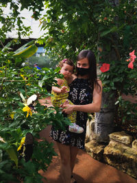 Full length of woman standing against plants