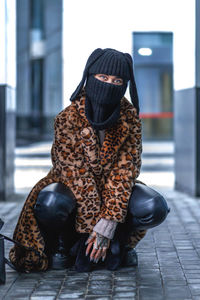 Rear view of woman sitting on street