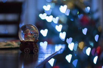 Close-up of christmas decoration on table in illuminated room